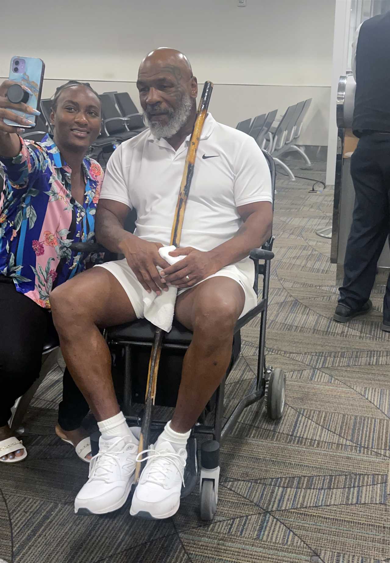 Mike Tyson, 56, pictured in wheelchair holding walking stick as fearsome boxing legend is pushed through Miami airport